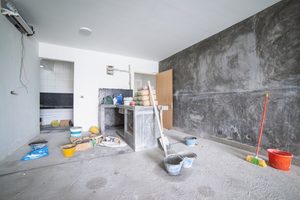 Unfinished room with exposed walls, construction materials and cleanup tools - demolition in louisiana - cypress line services