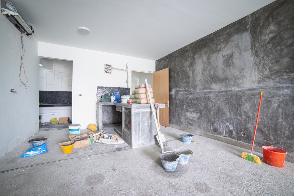 Unfinished room with exposed walls, construction materials and cleanup tools - demolition in louisiana - cypress line services